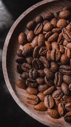 a wooden bowl filled with coffee beans