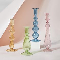 four different colored vases sitting next to each other