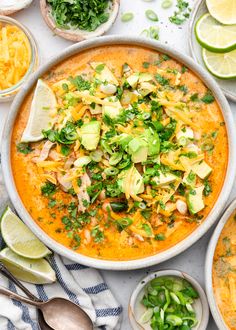 an overhead view of a bowl of mexican soup with tortilla chips and limes on the side