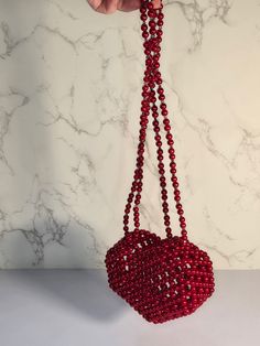 Handmade Heart Shaped beaded bag.  This Beautiful red beaded bag will be a perfect COMPLEMENT to your Valentine's date outfit❤️ The strap is 47 inches long and you can fold it in two halves🤩 Don't worry about the bag breaking or the strap, cause I used 40lb  fishing line and it makes the bag pretty sturdy. Plus I make my bags by using a special technique.  The bag is made of acrylic pearl beads with a touch of Preciosa Czech beads . Those small crystal beads make the bag look so stylish.  The bag will fit: airpods, small cardholder, lipstick, travel size perfume, keys, a small mirror and gum. The size is: H(4")*W(5.5")*D(2.5") Care instructions will be included in the order :) Red Beaded Bag As Gift, Red Beaded Bag For Gift, Heart-shaped Beaded Bag For Gifts, Heart-shaped Beaded Bag As Gift, Valentine's Day Gift Beaded Bag, Red Beaded Evening Bag As Gift, Red Beaded Bag, Valentines Date Outfit, Heart Shaped Bag