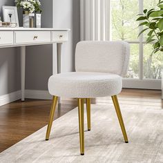 a white chair sitting on top of a wooden floor next to a desk with a potted plant