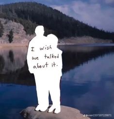 a man standing on top of a rock next to a lake