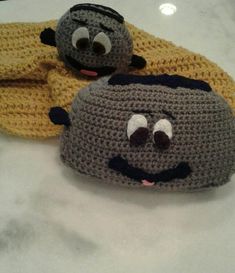 two crocheted hats sitting on top of a counter