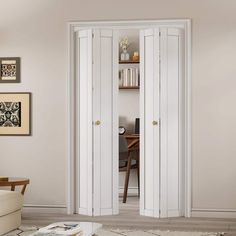 a living room with two white doors and a coffee table in the corner next to it