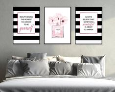 two pink and black paintings on the wall above a bed in a room with pillows