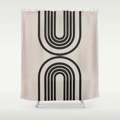 a black and white shower curtain with an intertwined design on the bottom, in front of a gray background