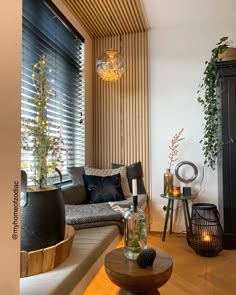 a living room filled with furniture next to a window covered in wooden slatted blinds