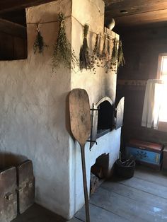 an old fireplace with plants growing on the wall and hanging from it's sides