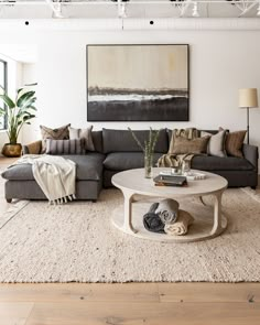 a living room filled with furniture and a large painting on the wall above the couch