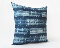 a blue and white pillow on a white background