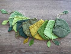 five different colored leaves on a wooden surface with string attached to the top and bottom of each leaf