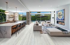 a living room filled with furniture and a fire place in the middle of a kitchen