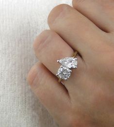 a person's hand holding a diamond ring