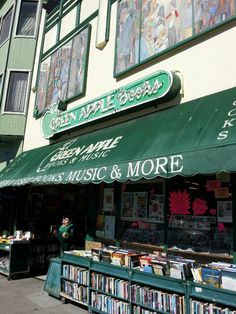 the outside of a book store with many books on display