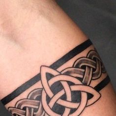 a tattoo on the arm of a man with an intertwined knot in black and white