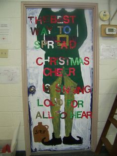 a door decorated with the words merry christmas cheer and an image of a man's body