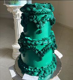 a three tiered cake with green frosting