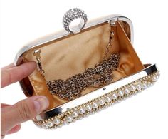 The AUBREE Clutch is a stylish and sophisticated accessory. With a pearl finish, this clutch offers a timeless beauty that will turn heads. With its sleek design, this clutch is the perfect accessory for any special occasion. Detachable Chain Included Approximate Size: 16.5 cm (L) x 4.5 cm (W) x 9.5 cm (H) Gold Pearl Clutch For Parties, Gold Pearl Party Clutch, Party Gold Pearl Clutch, Elegant Party Clutch With Pearl Handle, Luxury Pearl Clutch For Party, Pearl Clutch For Party, Elegant Pearl Evening Bag For Party, Chic Pearl Clutch For Party, Gold Pearl Evening Bag For Events