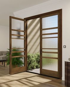 an open wooden door leading to a living room with potted plants in the window