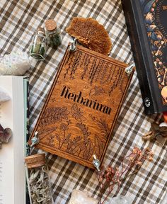 an open book sitting on top of a checkered table cloth next to other items