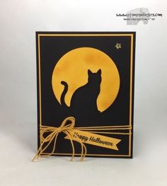 a black and yellow card with a cat sitting on it's side in front of a full moon