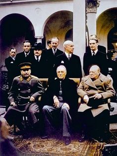 a group of men sitting next to each other in front of a building