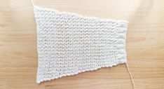 a white crocheted piece of cloth sitting on top of a wooden table