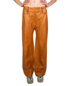 These runway designer pants are the epitome of luxury, with buttery soft burnt orange lambskin on the outside and a 100% silk lining. Leather panels at the knee create a wide leg fit. The button has the CC emblem embossed in a grid that pays homage to their classic quilted bags. Step into Paris when you adorn these next level leather pants! Designer: The infamous Chanel. Started by Coco Chanel in 1910, this brand is the height of french luxury designer clothing. Karl Lagerfeld was the creative d Luxury Brown Leather Bottoms, Luxury Leather Pants Standard Cut, Luxury Brown Chic Leather Pants, Luxury Brown Leather Pants, Luxury Full-length Faux Leather Pants, Pants Design, Quilted Bag, Burnt Orange, Karl Lagerfeld