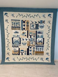 a blue and white quilt hanging on the wall