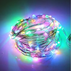 a string of multicolored lights on a purple background with the light shining brightly