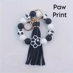 a black and white keychain with a paw print on it