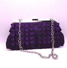 "This classic purple satin purse is from Jessica McClintock, circa 1990's. This item is in good vintage condition with minor signs of wear. It features pleated detailed satin, a silver chain shoulder strap, which tucks in if you want a clutch bag, a snap close and an inside side pocket.  It measures approximately 9-3/4\" wide x 5\" tall x and the silver shoulder chain measures 12\" in length. Jessica, who passed away in 2021 often spoke of her belief that \"Romance is beauty that touches the emo Elegant Purple Evening Bag For Formal Occasions, Purple Evening Clutch Shoulder Bag, Purple Clutch Shoulder Bag For Evening, Evening Purple Clutch Shoulder Bag, Elegant Purple Evening Bag, Purple Clutch Shoulder Bag For Formal Occasions, Purple Clutch Evening Bag For Formal Occasions, Purple Clutch Evening Bag For Events, Formal Purple Clutch Shoulder Bag