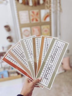 a person holding up four different types of stickers in their hand, with the words on them