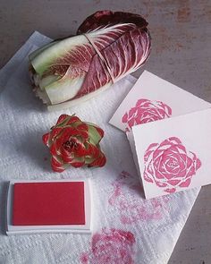 some red and green items on a white table cloth next to a pink rose flower