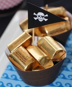 there is a pirate flag on top of some gold bars in a cupcake tin