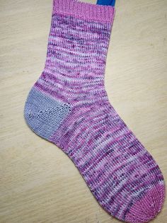 a pair of pink and blue socks sitting on top of a wooden table