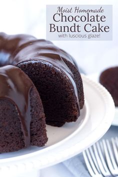 a chocolate bundt cake on a white plate with one slice cut out and ready to be eaten