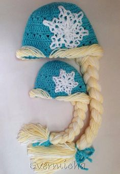 two crocheted hats with braids and snowflakes