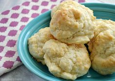 three biscuits stacked on top of each other in a blue plate with pink and white tablecloth