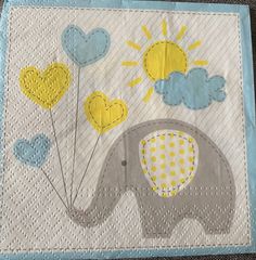 an elephant with yellow and blue balloons on it's back is sitting in the middle of a quilt