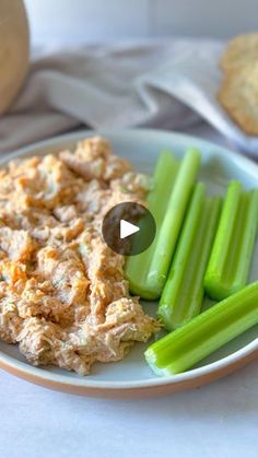 a white plate topped with celery next to crackers