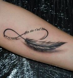 a black and white photo of a feather tattoo