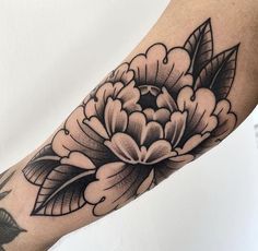 a black and white flower tattoo on the arm