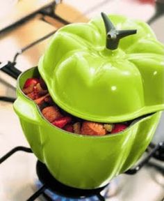 an apple shaped container filled with food on top of a stovetop oven burner