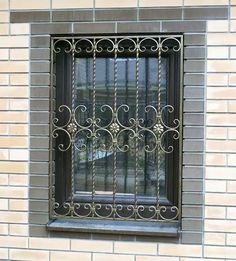 a window with iron bars on the side of a brick building