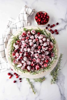 fresh cranberries in a bowl with rosemary sprigs