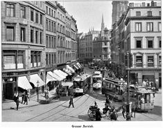 an old black and white photo of people on the street