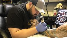 a man getting his arm tattoo done by someone