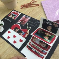 a table topped with pictures and cards on top of a wooden table next to a cup of coffee