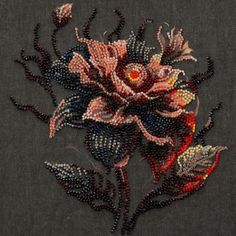 a close up of a flower on a piece of cloth with bead work in the middle